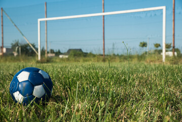 piłka nożna na tle nieczynnego boiska ligowego w słoneczny dzień