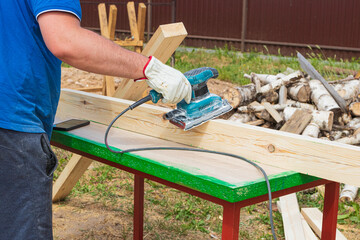 tree. natural wood in the shape of a rectangle. work piece. a man uses a tool to grind. sale.