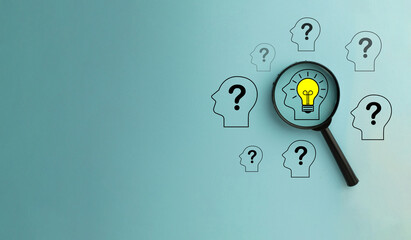 Magnify focus on Head with glowing light bulb icon among Head with Question mark icon over blue...