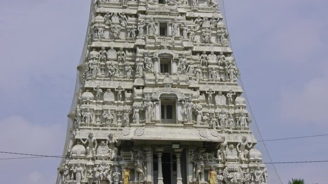 The Indian Hindu temple showcases a shikhara or tower adorned with god sculptures