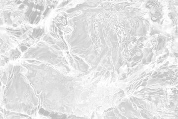 White water with ripples on the surface. Defocus blurred transparent white colored clear calm water surface texture with splashes and bubbles. Water waves with shining pattern texture background.