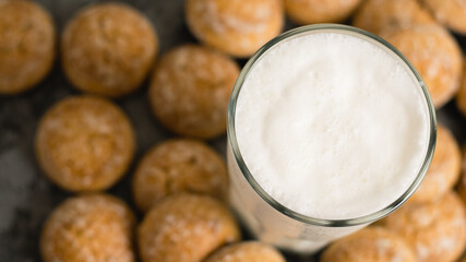 Flatlay, a delicious, refreshing summer drink in a glass, a milkshake made of milk and ice cream. Sweet foam cocktail close-up. Gingerbread on a dark table