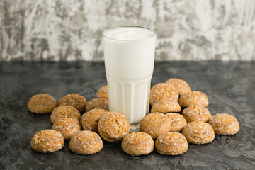 A delicious, refreshing summer drink, a milkshake made of milk and ice cream. Gingerbread on a dark table