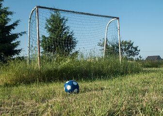 piłka nożna na tle nieczynnego boiska ligowego w słoneczny dzień