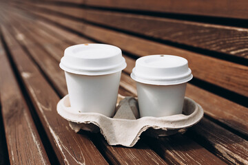 Delivery in any weather around the clock to the client. Fast food eco packaging. Two take out coffee in holder. Place logo on mug, mockup.