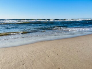 Blue seascape, waves on the sea, sandy coastline, empty beach