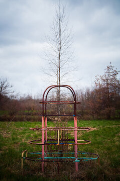 An abandoned, rusty jungle gym stands in an empty field on a farm in Ohio