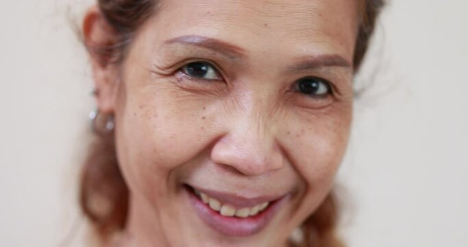 Slow motion VDO. portrait happy smile asian senior woman looking at camera at home.