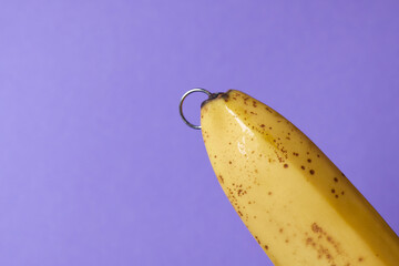Banana with piercing decoration. Minimal piercing concept.