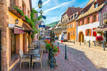 Sidwalk cafes and shops line the picturesque streets of the village of Kaysersberg, France, one of...