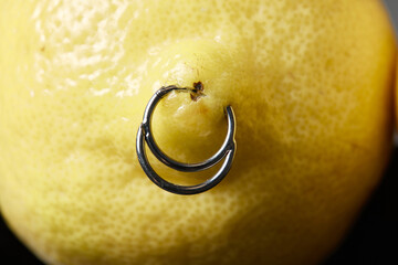 piercing earrings in a lemon on an background.