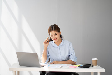 Charming Asian businesswoman focusing on her work, using her smartphone to contact with her clients.