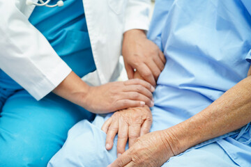 Doctor taking care, help and encourage Asian elder senior woman patient in clinic hospital.