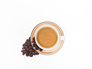 Cup of coffee with coffee beans isolated on white background. Milk coffee or caffe latte in a mug beside a pile of beans against a white background.