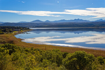 Late afternoon with cloud reflections over a large lake with reeds and waterfowl near Knysna, South Africa.