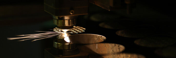 Laser machine cutting metal sheet and neon sparks flying out