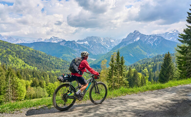 cheerful active senior woman on a E mountain bike tour at Vršič Pass in the Triglav National Park, Julian Alps above Kranska Gora in Slovenia