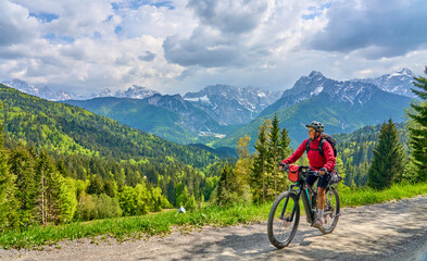 cheerful active senior woman on a E mountain bike tour at Vršič Pass in the Triglav National...
