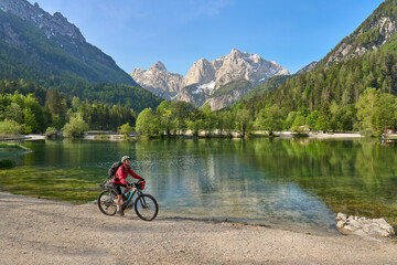 active senior woman on a mountain bike tour at Lake Jezero Jasna in the Triglav National Park near Kranska Gora, Julian Alps, Slovenia