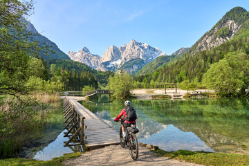 Fototapeta na wymiar active senior woman on a mountain bike tour at Lake Jezero Jasna in the Triglav National Park near Kranska Gora, Julian Alps, Slovenia