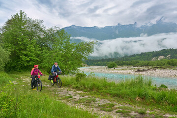 Fototapeta na wymiar active senior couple on a e-bike tour in the Valley of River Soca, Triglav National Park near Bovec, Slovenia