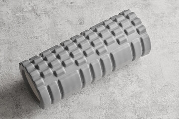 Gray foam roller for muscle relaxing massage isolated on white background. Myofascial release...