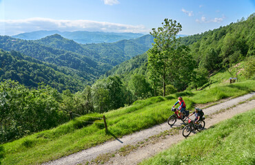 active senior couple on a bike tour with their electric mountain bikes in the Karst Mountains of Slovenia near Solkan