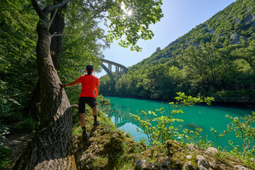 woman resting during a hiking tour along turquoise River Soca in the  Julian Alps in Slovenia
