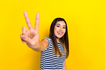 Photo of chinese funny woman showing v-sign you hello symbol greetings friendly toothy beaming smile isolated on yellow color background © deagreez