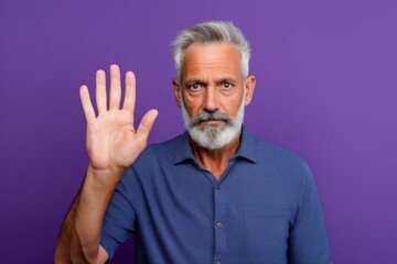 Fototapeta premium Medium shot portrait photography of a tender mature man making a sorry gesture with hands together against a vibrant purple background. With generative AI technology
