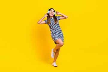 Fototapeta na wymiar Full length photo of positive lady wear stylish clothes listen mp3 player looking up offer empty space isolated on yellow color background
