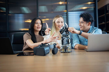Young people sitting at a desk wearing VR glasses while trying out a robotic arm projec