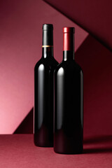 Bottles of red wine on a red background.