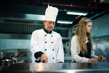 cooking under the guidance of seasoned chefs at a culinary school's kitchen.