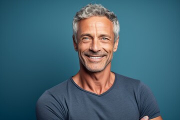 Obraz premium Close-up portrait photography of a beautiful mature man giving a hug to the camera against a soft blue background. With generative AI technology