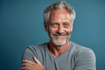 Obraz premium Close-up portrait photography of a beautiful mature man giving a hug to the camera against a soft blue background. With generative AI technology