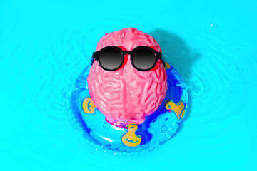 Brain Character Wearing Sunglasses Floats on an Inflatable Tube