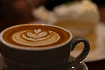 Close up a cup of hot latte art coffee on wooden table.A cappuccino is an espresso-based coffee drink with steamed milk foam.Best of menu in the coffee shop or restaurant.