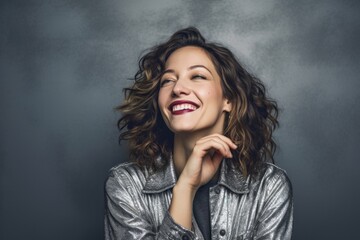 Fototapeta premium Lifestyle portrait photography of a happy girl in her 30s blowing air kisses at camera against a metallic silver background. With generative AI technology