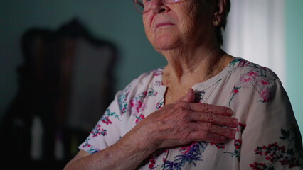 Religious Elderly woman doing Sign of the Cross. Catholic theme of older senior Faithful person...