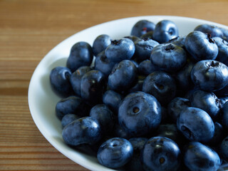 Freshly picked blueberries in a white vintage ceramic bowl. Selective focus, Free text space.