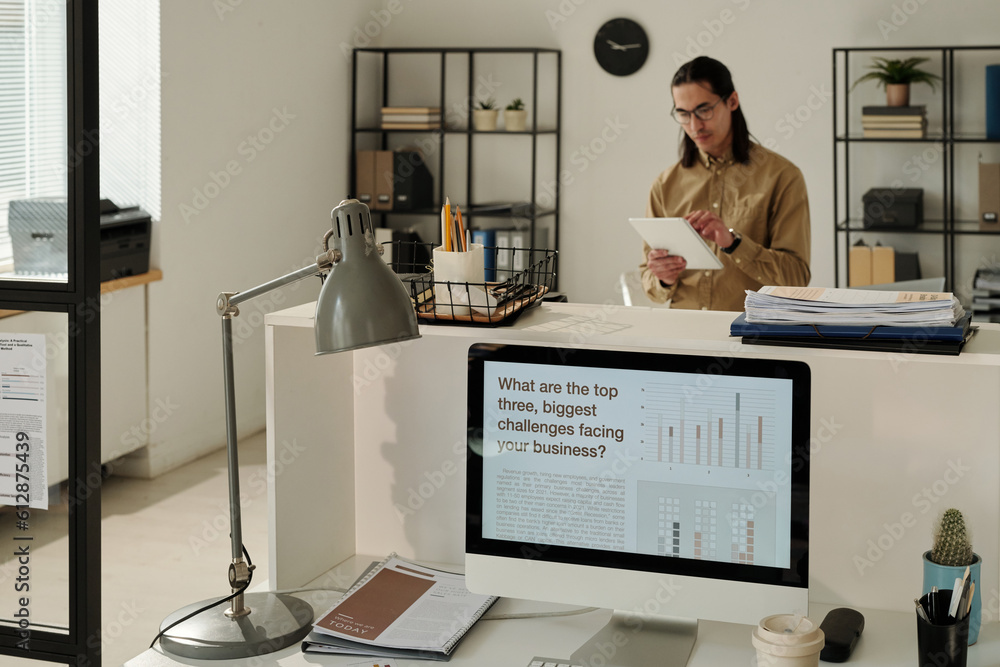 Aufkleber Screen of computer with various types of data on workplace of financial manager or economist standing on background and using tablet