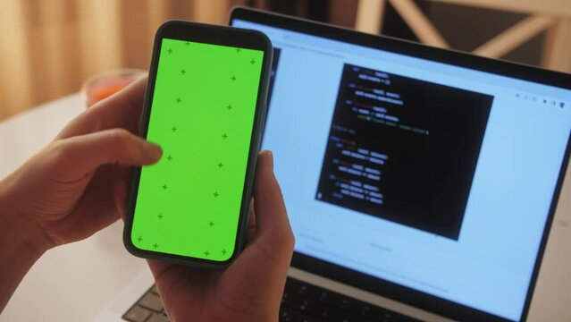 Phone with chroma key green screen with man working with chatbot AI online, connecting with AI and using a chat. IT engineer software developer programmer interact with chat bot, making