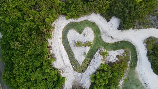 Aerial view of heart-shaped pond and white sand beach on tropical island of Maldives. 4K footage drone video
