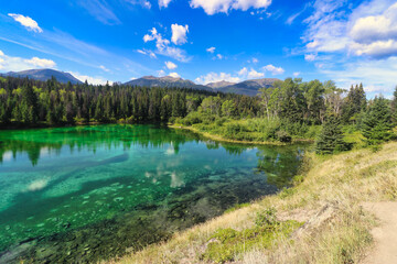 Fototapeta na wymiar Crystal clear, emerald and sapphire hued lake waters in the Valley of Five Lakes region of Jasper in the Canada Rockies