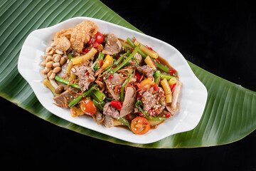 Thai food, Papaya salad with cucumber. spicy food traditional of asian Thai. Papaya salad on white plate, Close up papaya salad spicy with green leaf background, Asian food