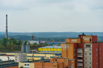 An oil refinery on the territory of the city. The plant is between the forest and the city. A chimney from a gas turbine plant emits poisonous smoke over the city.