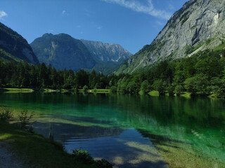 Fototapeta na wymiar Bluntausee, Salzburger land, Austria. Mountain lake. Alps. Blue crystal clear water. Summer rocky landscape. Hiking place. Green landscape. Trees. Lake coastline.