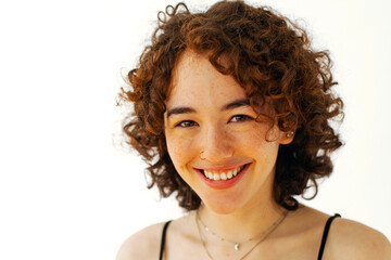 woman with curly hair smiling, toothy smile headshot, looking at camera