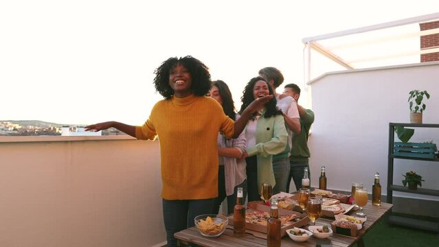 rooftop party, multiracial young people dancing drinking beer
